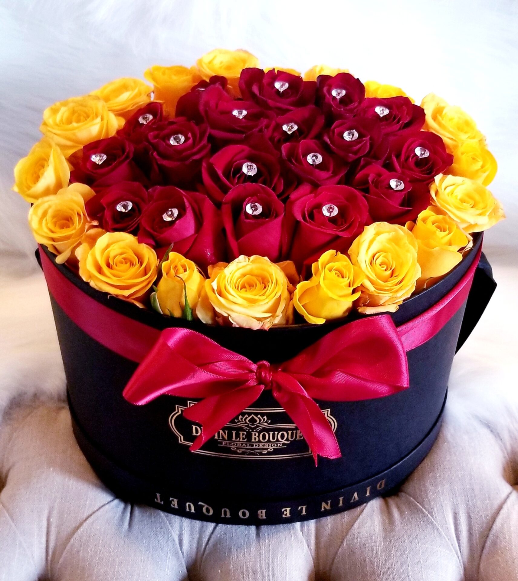 A hat box filled with red and yellow roses.