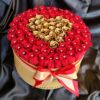 A large round box of roses with gold ribbon.