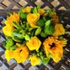 A bouquet of yellow flowers and green leaves.