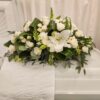 A white casket with flowers on it.