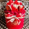 A red hat box with some white and pink ribbons