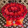 A red bouquet of roses in a yellow box.