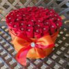 A red rose bouquet in an orange box.