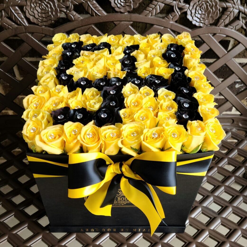 A black and yellow box with roses on top of it.